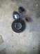1987 Ford Bronco II - Several automotive parts, including rubber pieces and a metal flange, lie on a concrete surface.