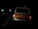 1969 Ford Bronco - Bus rear view at night, showing taillights and yellow and white body.
