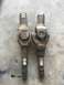 1984 Ford Bronco - A comparison of two driveshaft U-joints is shown, resting on a concrete floor.
