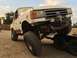 1984 Ford Bronco - This Ford truck, likely from the late 1980s, is being loaded onto a trailer with a winch system.