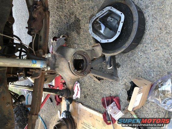 Front axle assembly with differential cover removed, showing suspension components and a Bilstein shock absorber