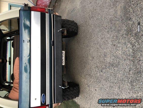 Dark green and white Ford Bronco rear with a license plate and large tires