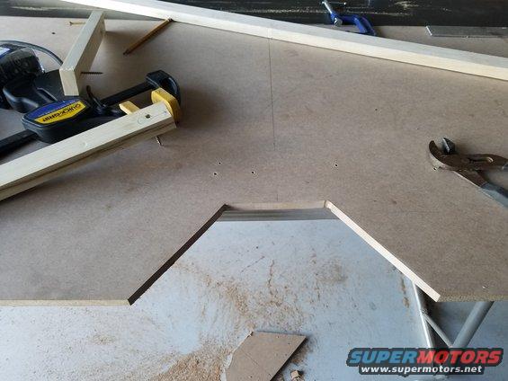 Workbench with Quick-Grip clamps, wood pieces, and pliers. Cutout in surface