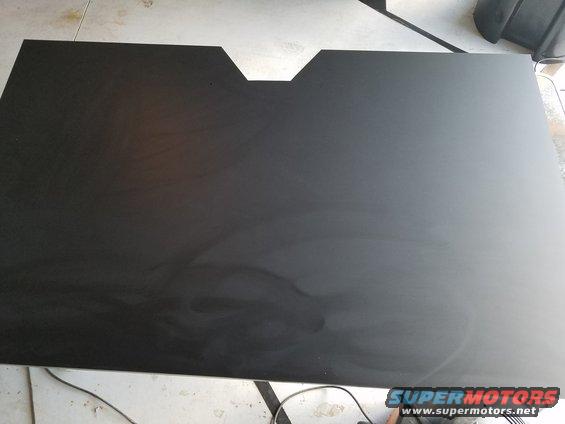 Black panel with a V-shaped cutout at the top edge, showing scuff marks