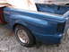 1971 Ford Ranchero - Close-up view of the rear passenger side of a blue pickup truck, showing the bed, fender, and a tarp covering part of the cargo area.