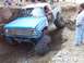 2000 Ford F-450 - Modified pickup truck with oversized tires is stuck in a deep dirt trench.