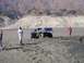 2000 Ford F-450 - A blue off-road truck is stuck in thick mud with two men standing nearby.
