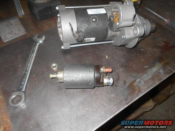 Starter motor and solenoid on a workbench with a wrench