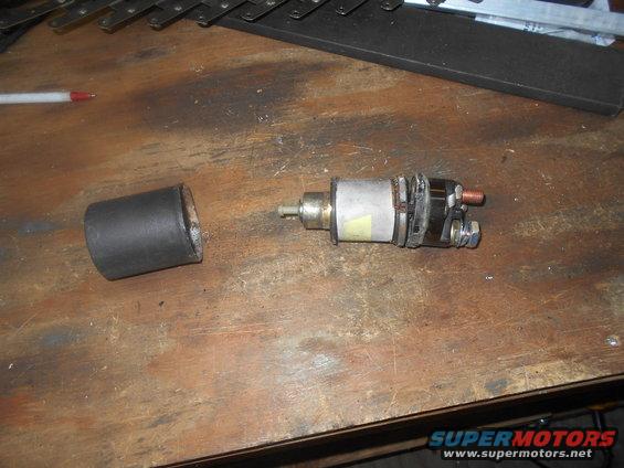 Starter solenoid and cap on wooden surface