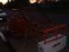 1990 Ford Bronco - Orange roll cage frame on a trailer, with a toolbox and a car in the background.