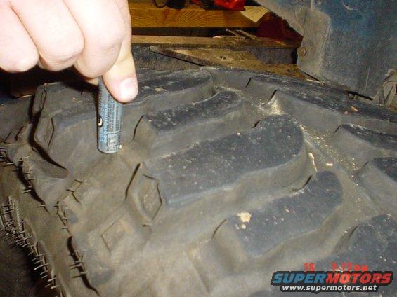 Tire tread depth gauge measuring a large off-road tire
