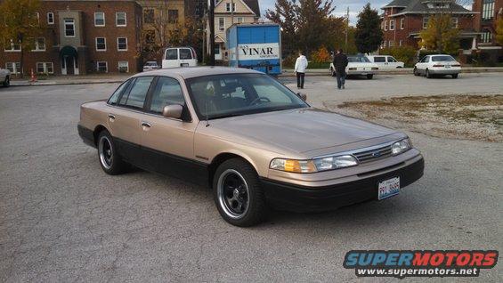 Tan 1995 Mercury Grand Marquis, 3/4 front view. Black trim and wheels