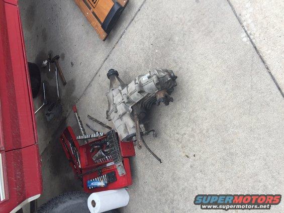 Transfer case and red toolbox with tools on concrete