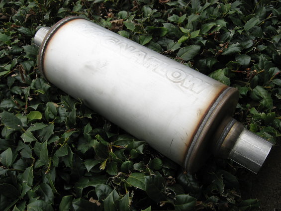 Magnaflow exhaust muffler lying on green leaves