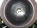 1987 Jaguar XJ6 - Interior view of a perforated exhaust pipe, showing the baffle and a glimpse of greenery beyond.
