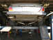1987 Jaguar XJ6 - The rear of a 1987 Jaguar XJ6 is shown on a lift, focusing on its dual exhaust system.