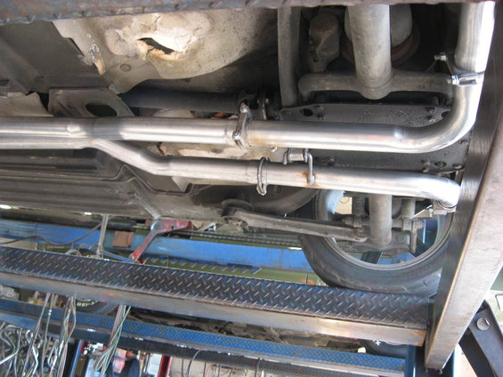 Underside view of a car's exhaust system, showing pipes and clamps