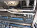 1987 Jaguar XJ6 - The exhaust system of a vehicle is visible from underneath, mounted on a lift.