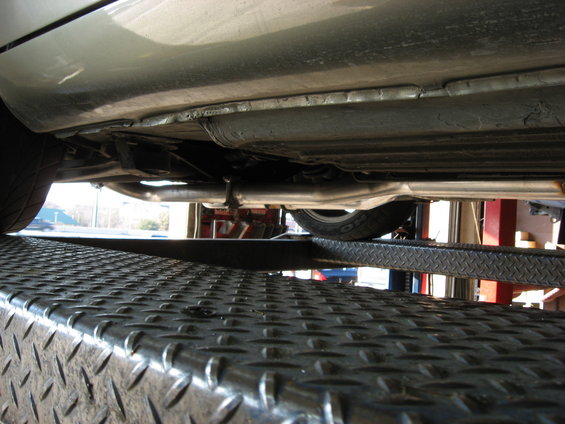 Underside view of a car's exhaust system on a lift
