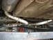 1987 Jaguar XJ6 - The underside of a vehicle shows a newly installed stainless steel exhaust system with clamps.