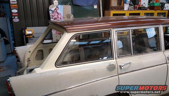 Station wagon with wood-grain roof trim, seen from the side in a garage