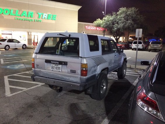 Silver Toyota 4Runner with a light blue camper shell parked at night, Texas license plate DBZ-0205