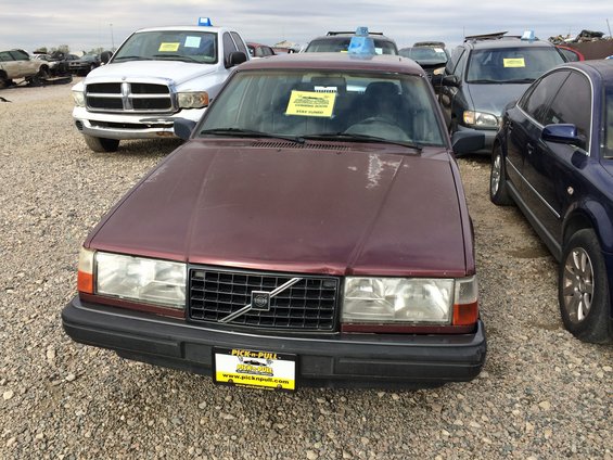 Maroon Volvo sedan with a black grille and a yellow 'Pick-n-Pull' license plate