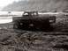2000 Ford F-450 - Ford pickup truck navigates a muddy terrain, kicking up spray.