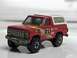 1979 Ford Bronco - A close-up view of a red toy truck, detailed with racing decals and a white camper shell.