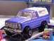1979 Ford Bronco - A blue 1978 Ford Bronco toy with a white top is displayed on a ramp in front of a toy sales office.