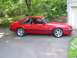 1986 Ford Mustang - This red 1986 Ford Mustang GT 5.0 features a side profile with distinctive aftermarket wheels and black trim.