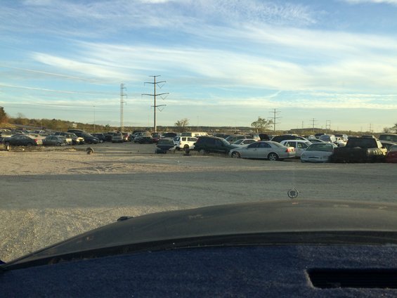Junkyard scene with multiple vehicles under a bright sky