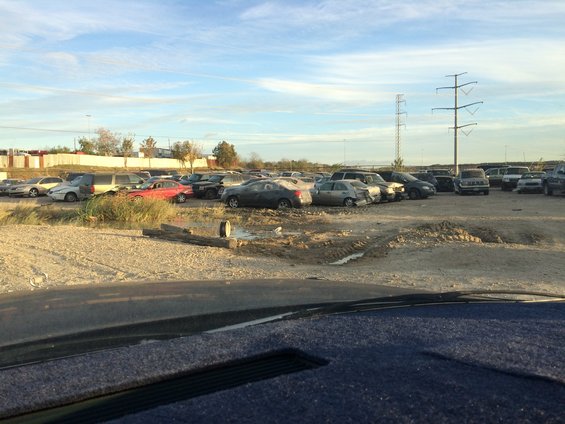Junkyard scene with many cars under a cloudy sky