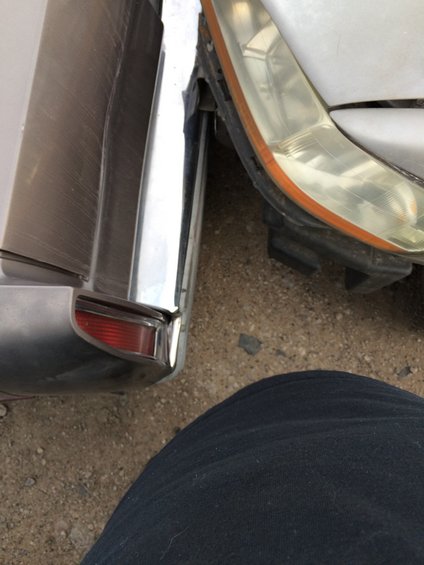 Close-up of a car's chrome bumper and a damaged headlight assembly