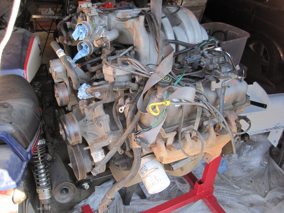 Engine on red stand with oil filter visible