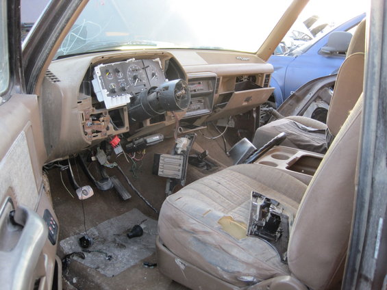 Interior view of a damaged vehicle with exposed wiring and torn seats