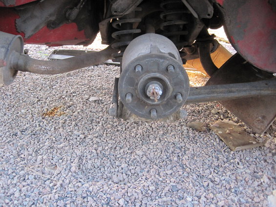 Rear suspension assembly with brake drum and exhaust pipe visible