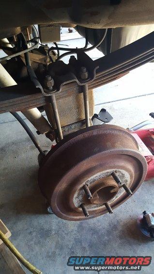 rear axle drum brake assembly with leaf springs and shock absorber