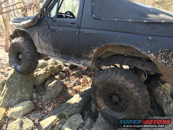 Black off-road SUV with snorkel, side view, on rocks