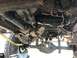 1989 Ford Bronco - The underside of a 4x4 vehicle shows a damaged drivetrain component and suspension system.