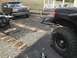 1989 Ford Bronco - A black Ford Bronco is parked next to a trailer, with another vehicle partially visible in the foreground.