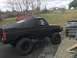 1989 Ford Bronco - This lifted 1987 Ford Bronco features a black soft top and is parked outdoors next to another Ford truck.