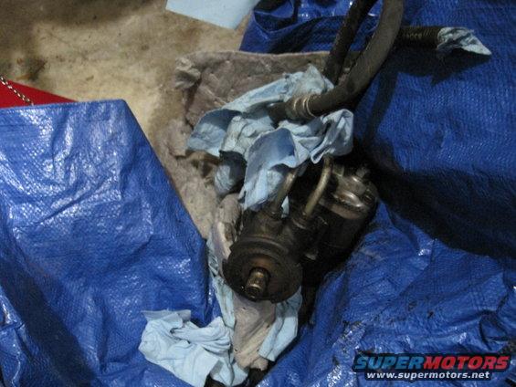 Power steering pump with hoses and rags, covered by blue tarp