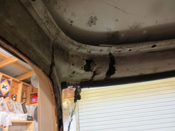 Close-up of severely rusted metal frame, likely part of a vehicle's body or chassis