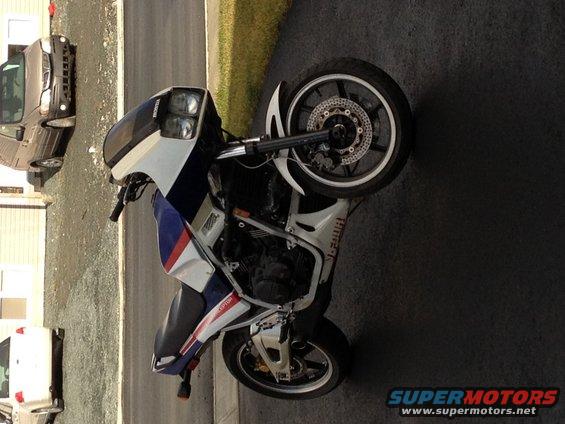 Honda motorcycle parked next to a dark SUV and a white vehicle