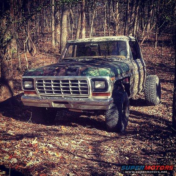 1979 Ford F-150 pickup truck with camouflage paint, parked in a wooded area