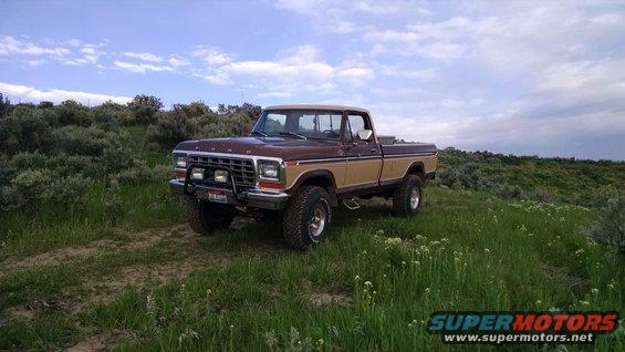Brown and tan Ford pickup truck parked on a grassy hill
