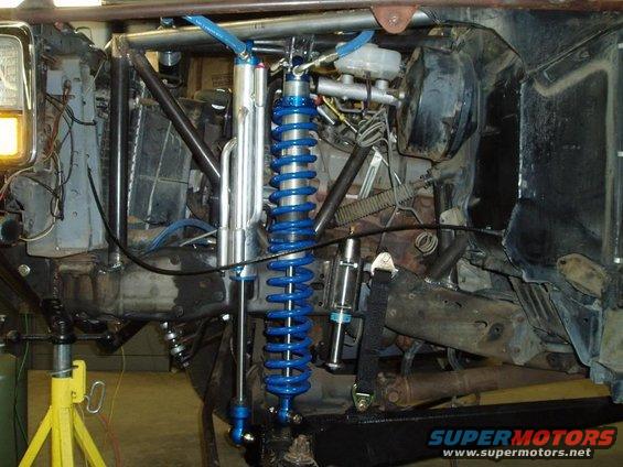 Custom off-road suspension with blue coilover shocks and suspension linkages