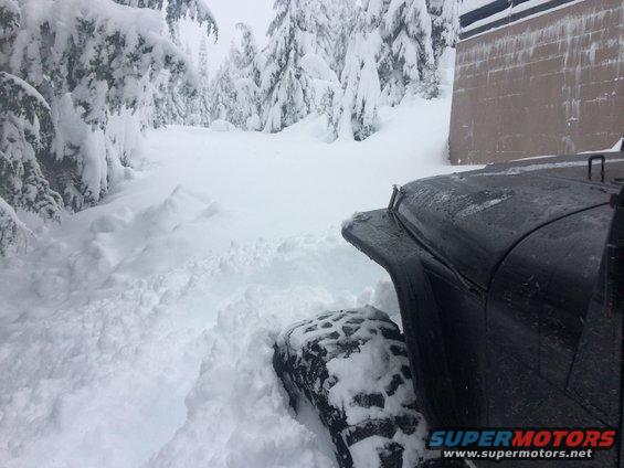 Black 1995 Jeep YJ in deep snow, front fender and tire visible