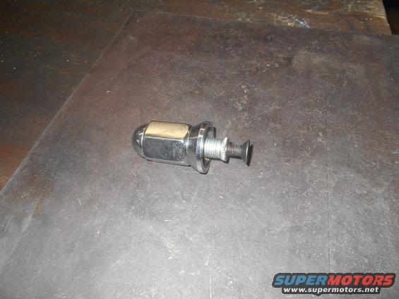 Chrome lug nut and bolt assembly on a dark surface